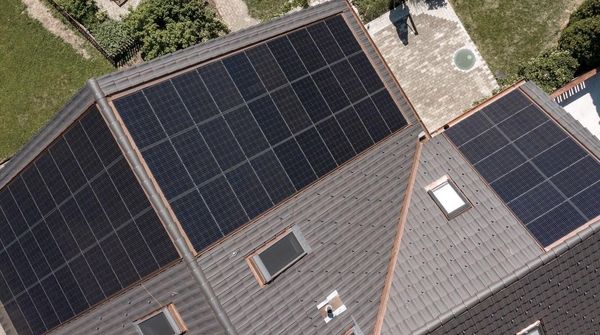 Draufsicht aus der Vogelperspektive auf ein Haus mit Garten und montierter PV-Anlage.