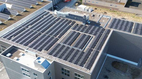Luftaufnahme der Industriehalle der R. Nussbaum AG mit einer grossen Solaranlage auf dem Dach. 