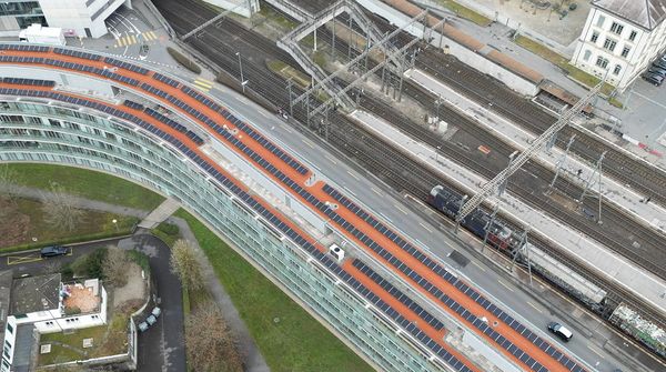 Luftaufnahme des Bürogebäudes der UBS Fund Management AG mit einer grossen Solaranlage auf dem Dach. 