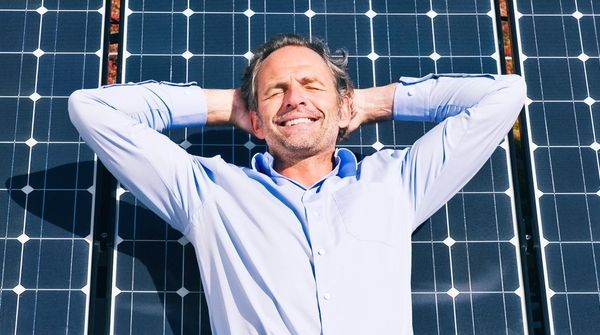 Business Person entspannt vor Solarpanel und geniesst Sonne