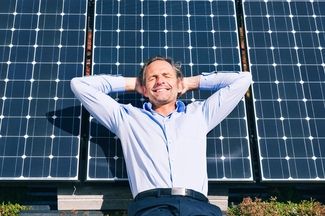 Business Person entspannt vor Solarpanel und geniesst Sonne